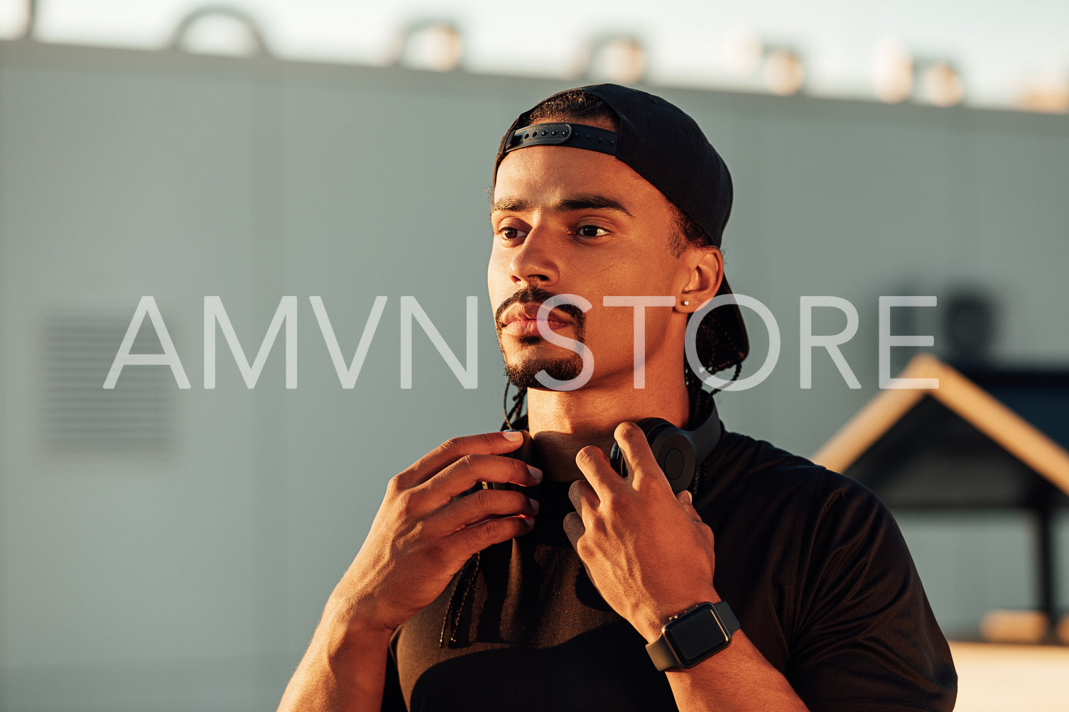 Portrait of a male athlete in cap looking away at sunset