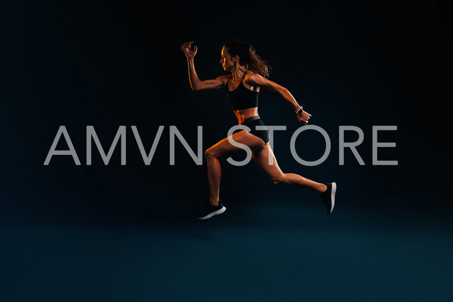 Sprinter against a black background. Muscular female running and jumping.