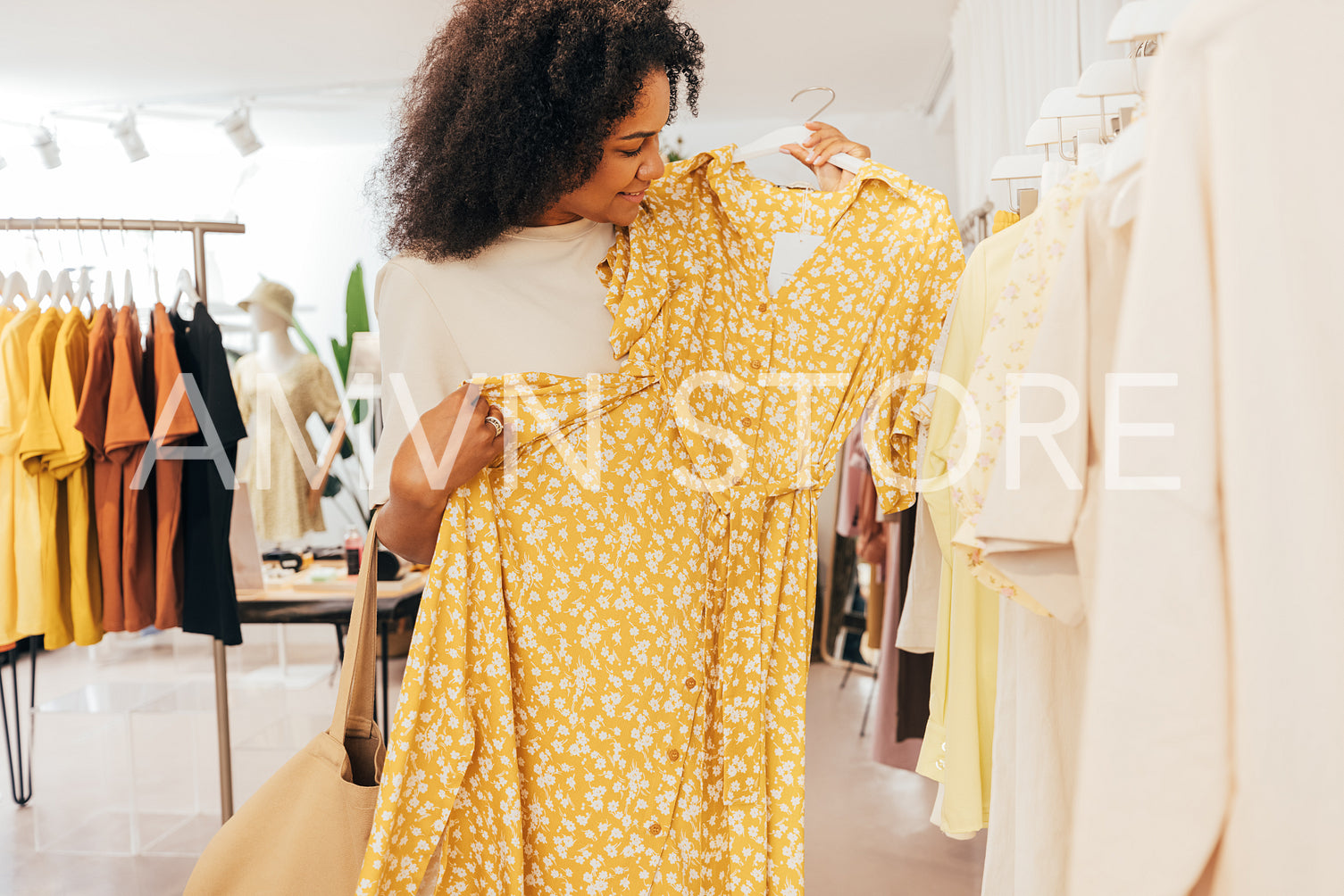 Woman choosing new clothes. Buyer in boutique looking on a dress