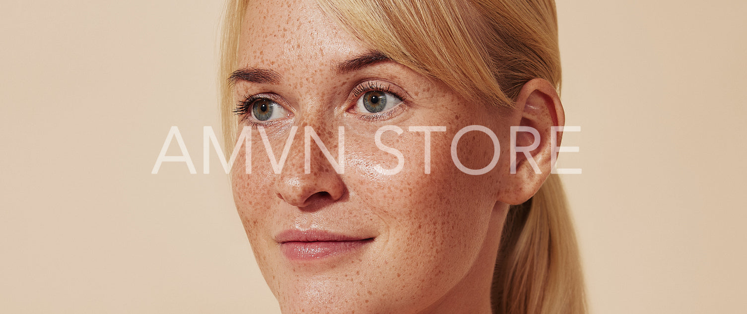 Cropped portrait of young blond woman with freckles. Female with smooth healthy skin against a pastel backdrop.