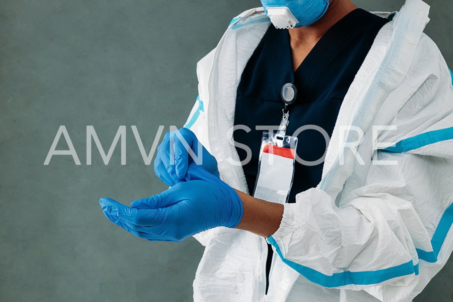 Mid section of unrecognizable female doctor takes off medical gloves at a wall	