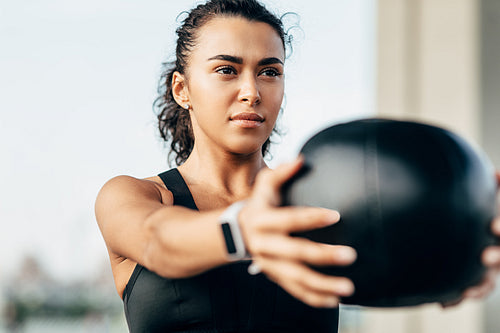 Young muscular woman exercising with a medicine ball