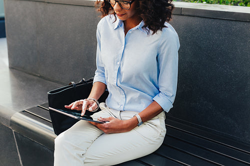 Cropped shot of african woman using digital tablet in city