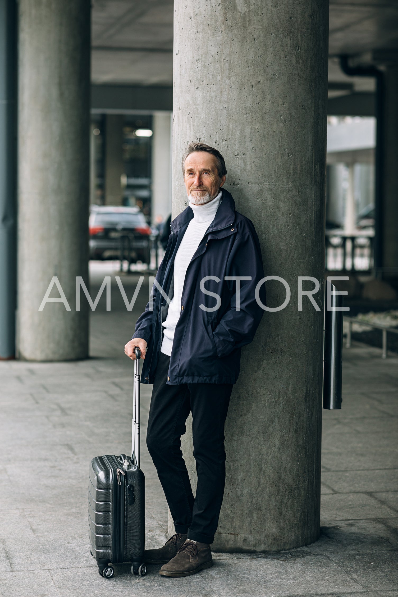 Senior man leaning on wall. Mature tourist standing outdoors with luggage.	