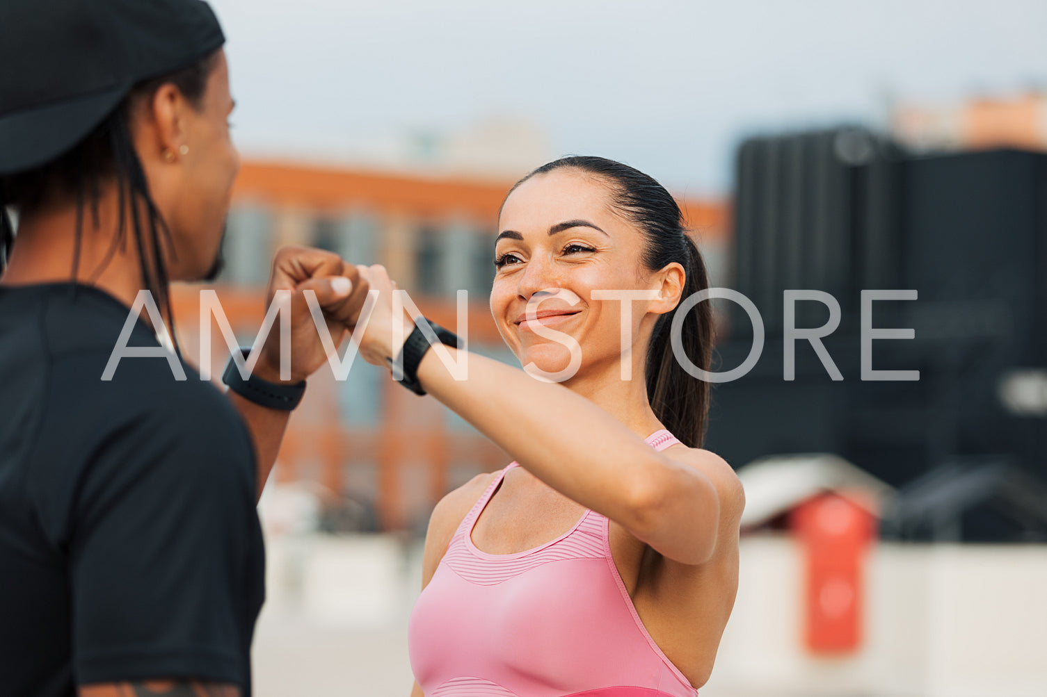 Young athletes giving fist bump after workout on the roof