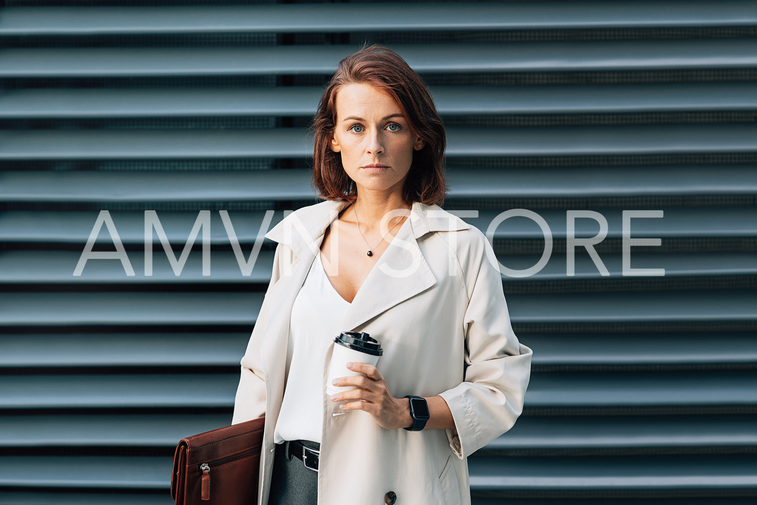 Confident businesswoman with ginger hair. Middle-aged business person wearing stylish clothes holding a leather folder.