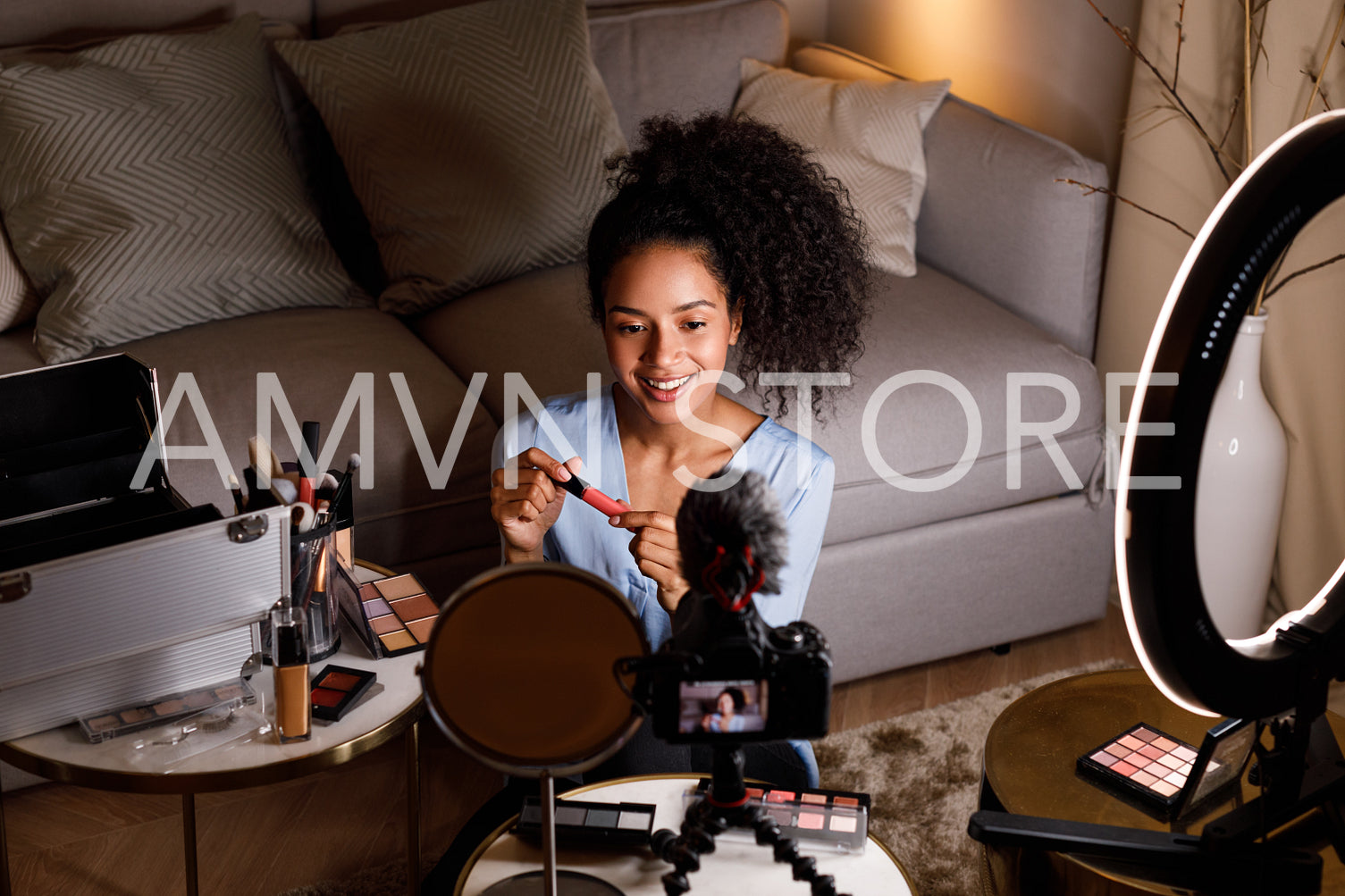 Young influencer making review for lipstick in living room	