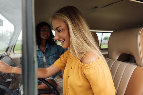 Side view of a blond woman on driver seat in a camper van