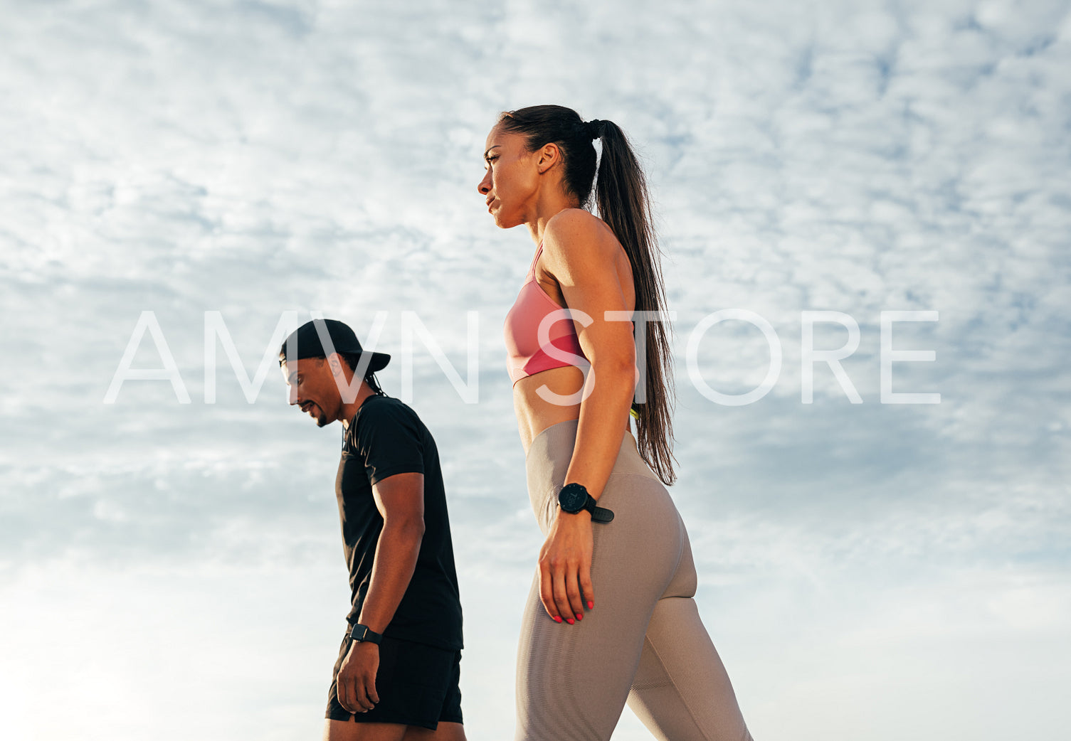 Low-angle shot of two athletes preparing to run outdoors