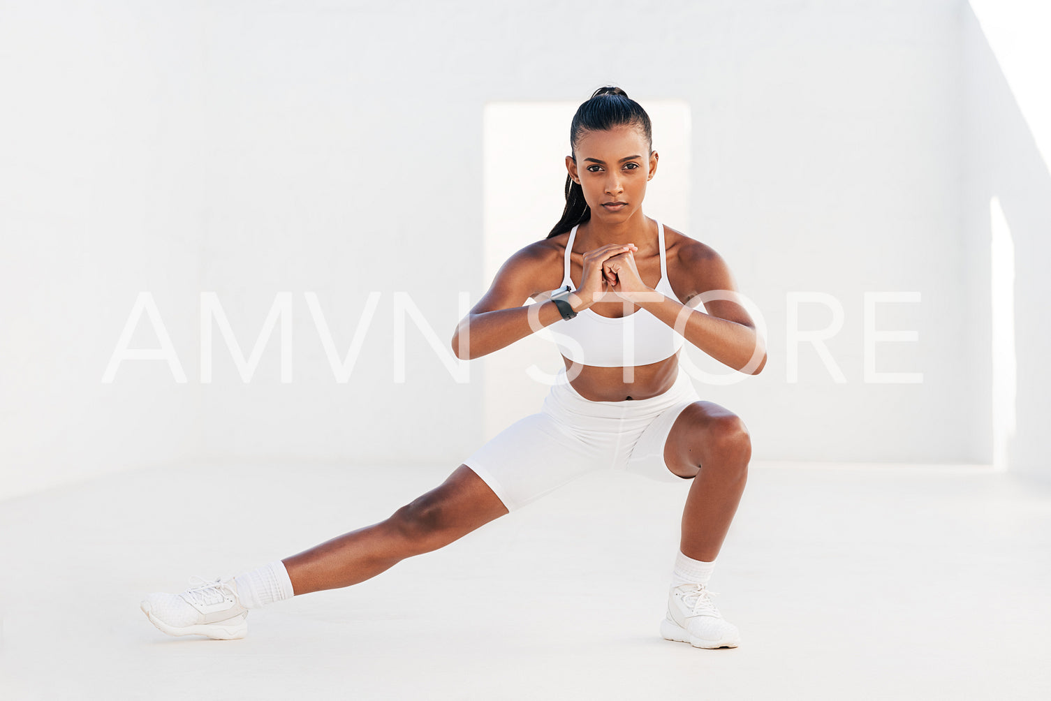 Confident fitness athlete flexing and warming up her body before an intense workout. Muscular woman practicing cardio exercises outdoors.