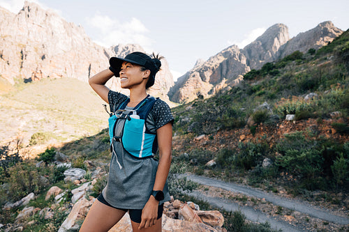 Smiling woman in fitness wear enjoying the view during hike