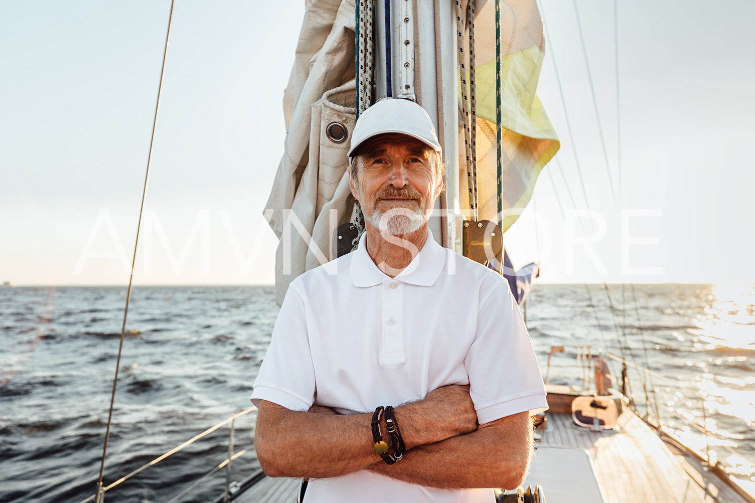 Portrait of a mature confident captain standing on his yacht at mast and looking at camera	