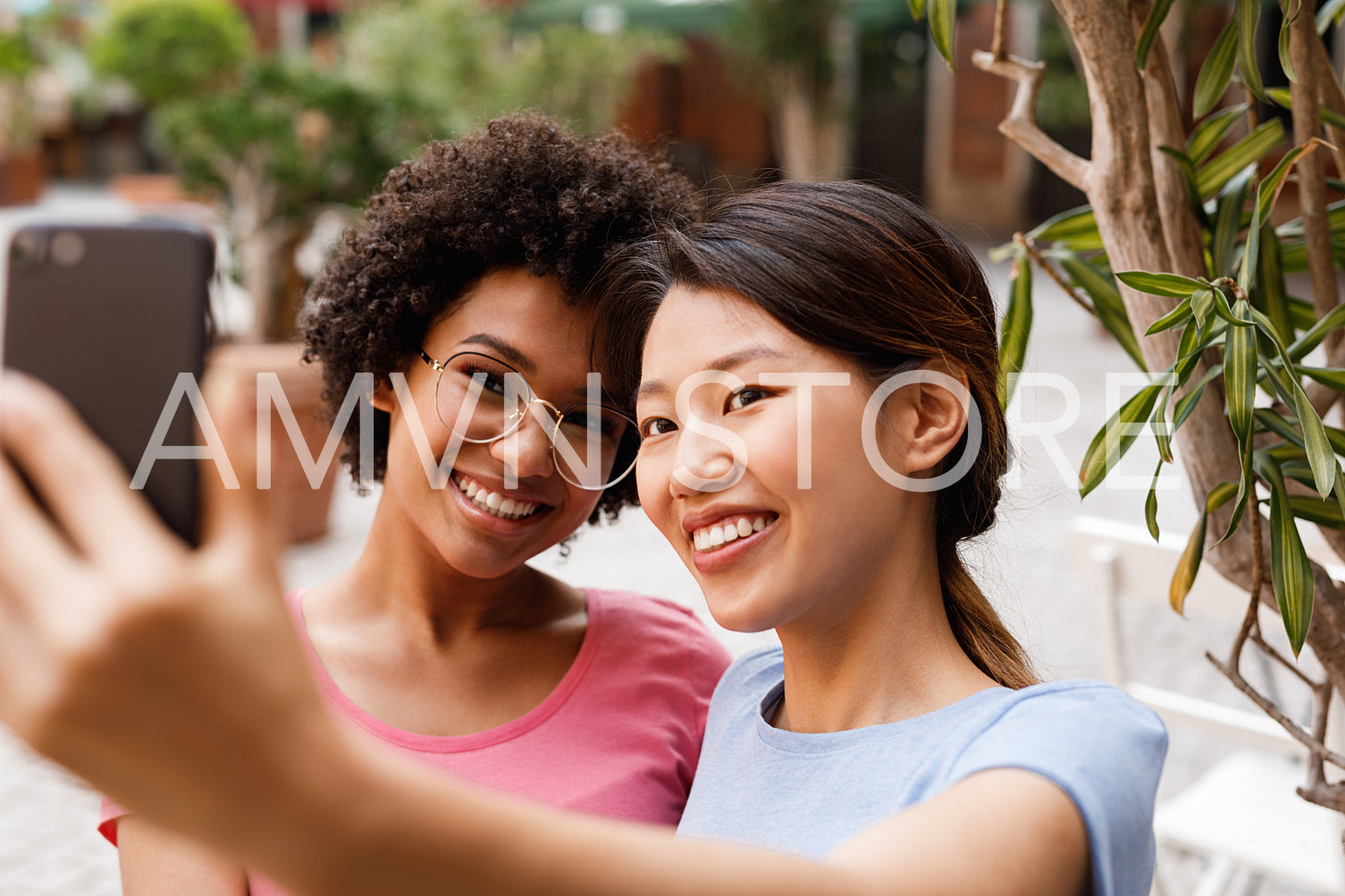 Two happy women taking selfie in outdoor restaurant	