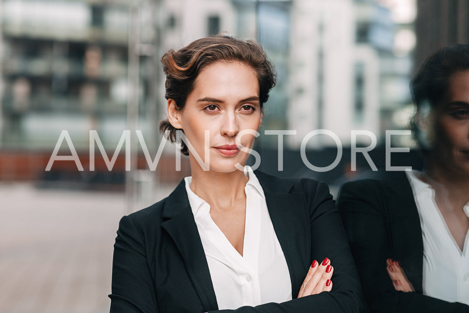 Confident businesswoman looking away. Portrait of young female in formal wear posing outdoors at office building with arms crossed.	