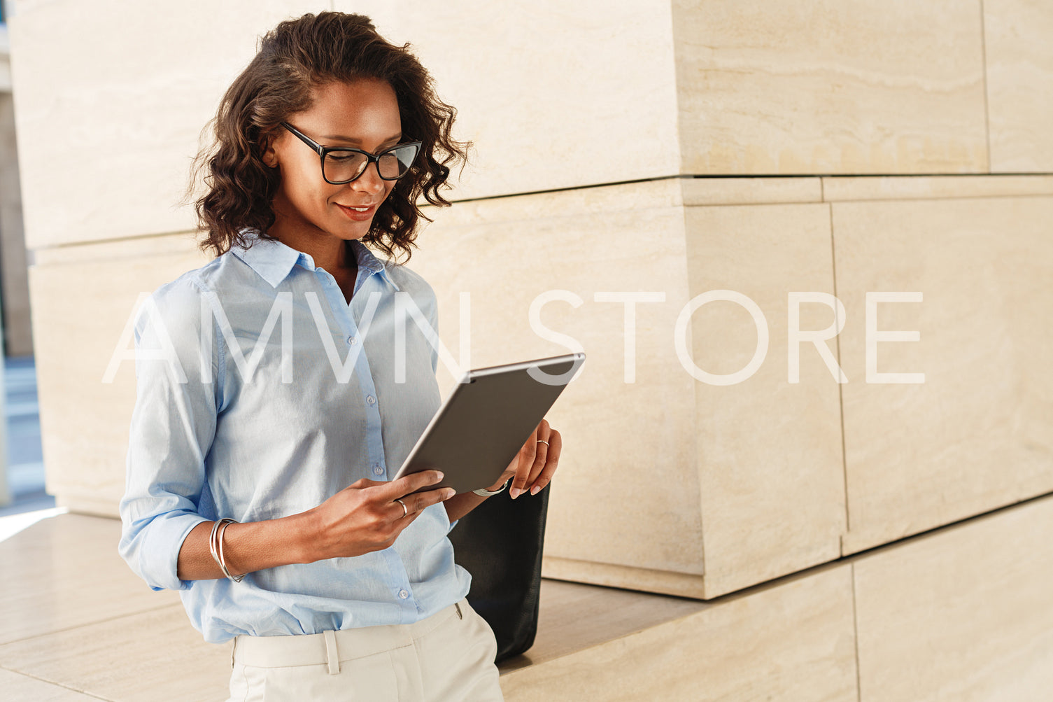 Young woman wearing eyeglasses reading and browsing on digital tablet	