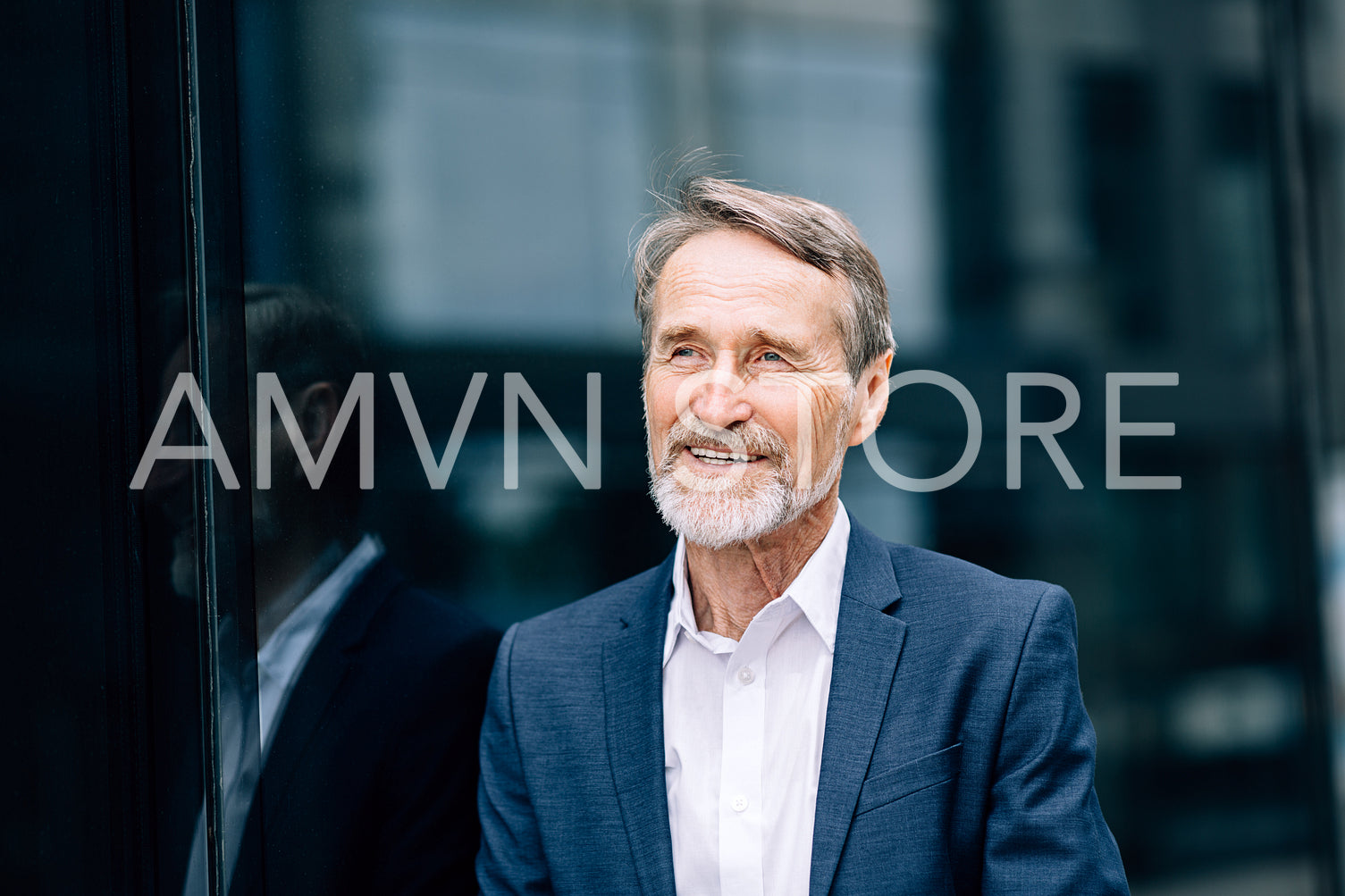 Smiling businessman standing outdoors at office building and looking away	