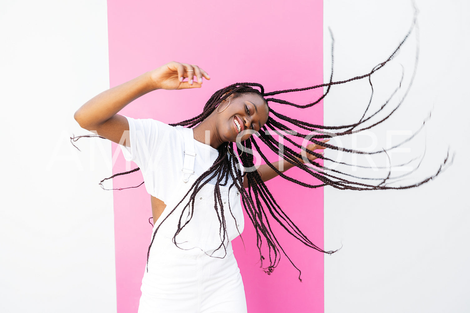 Young happy girl with braided hair having fun at white wall with pink stripe