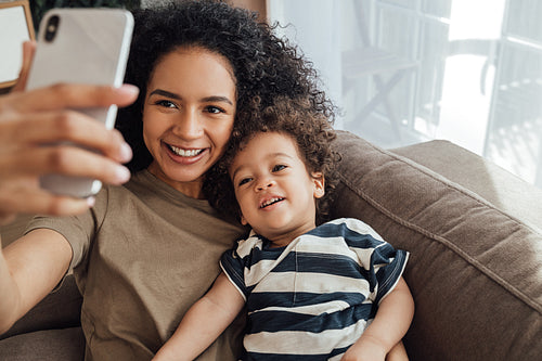 Young mother and her little son spending time together. Happy boy taking a selfie with his mother.