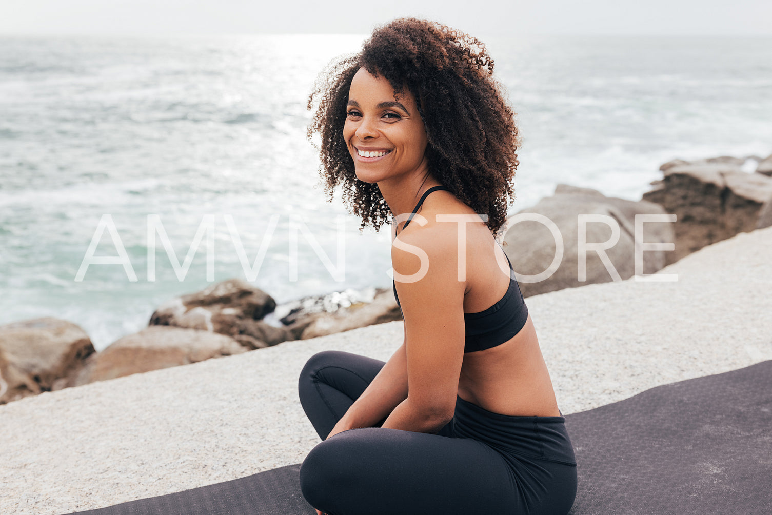 Cheerful female relaxing on mat. Woman looking away while relaxing after training.