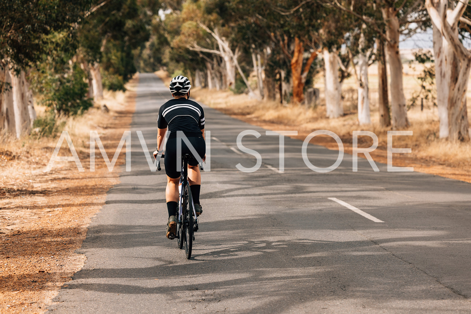 Rear view of professional female cyclist riding bicycle on count