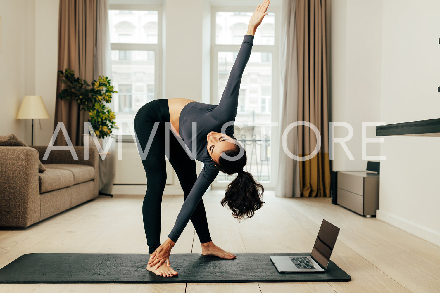 Woman repeating exercises at home. Young female keeps fit while staying at home during a pandemic.	