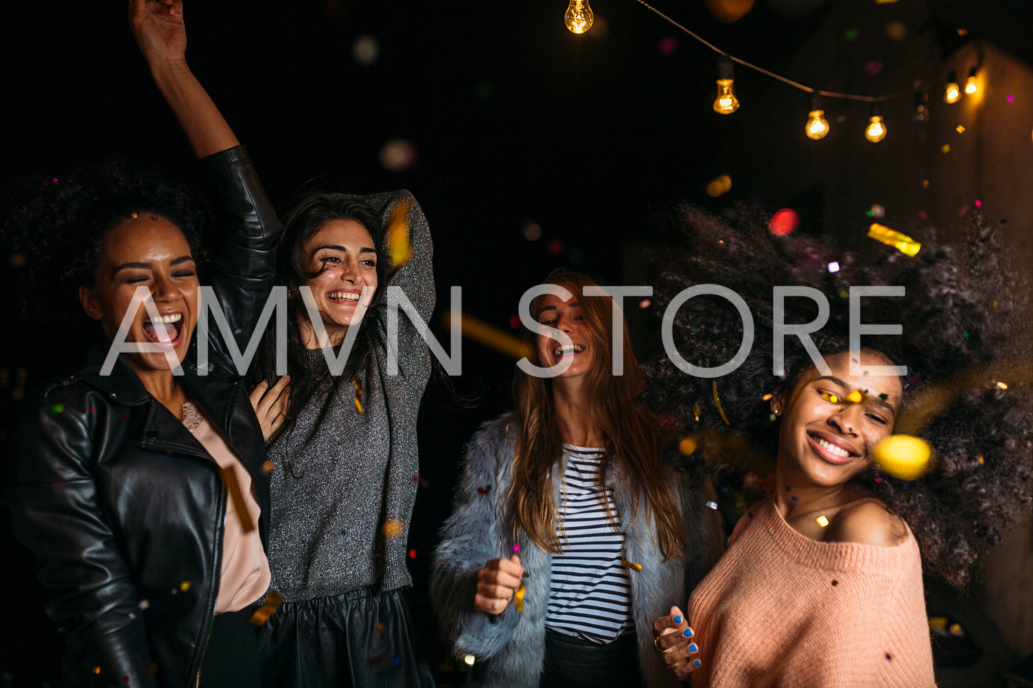 Group of female friends dancing at night under confetti	