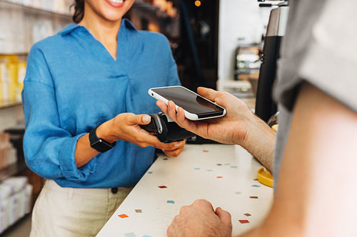 Customer paying bill through a smartphone using NFC technology