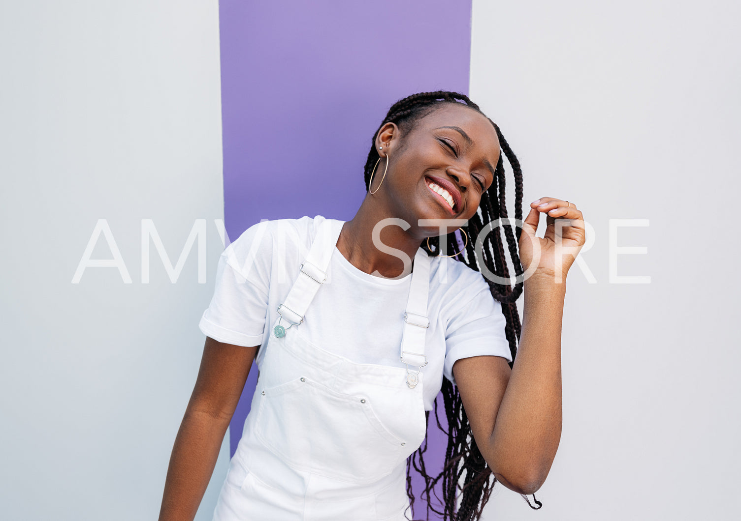 Young female with braids having fun. Girl in white overall with closed eyes.