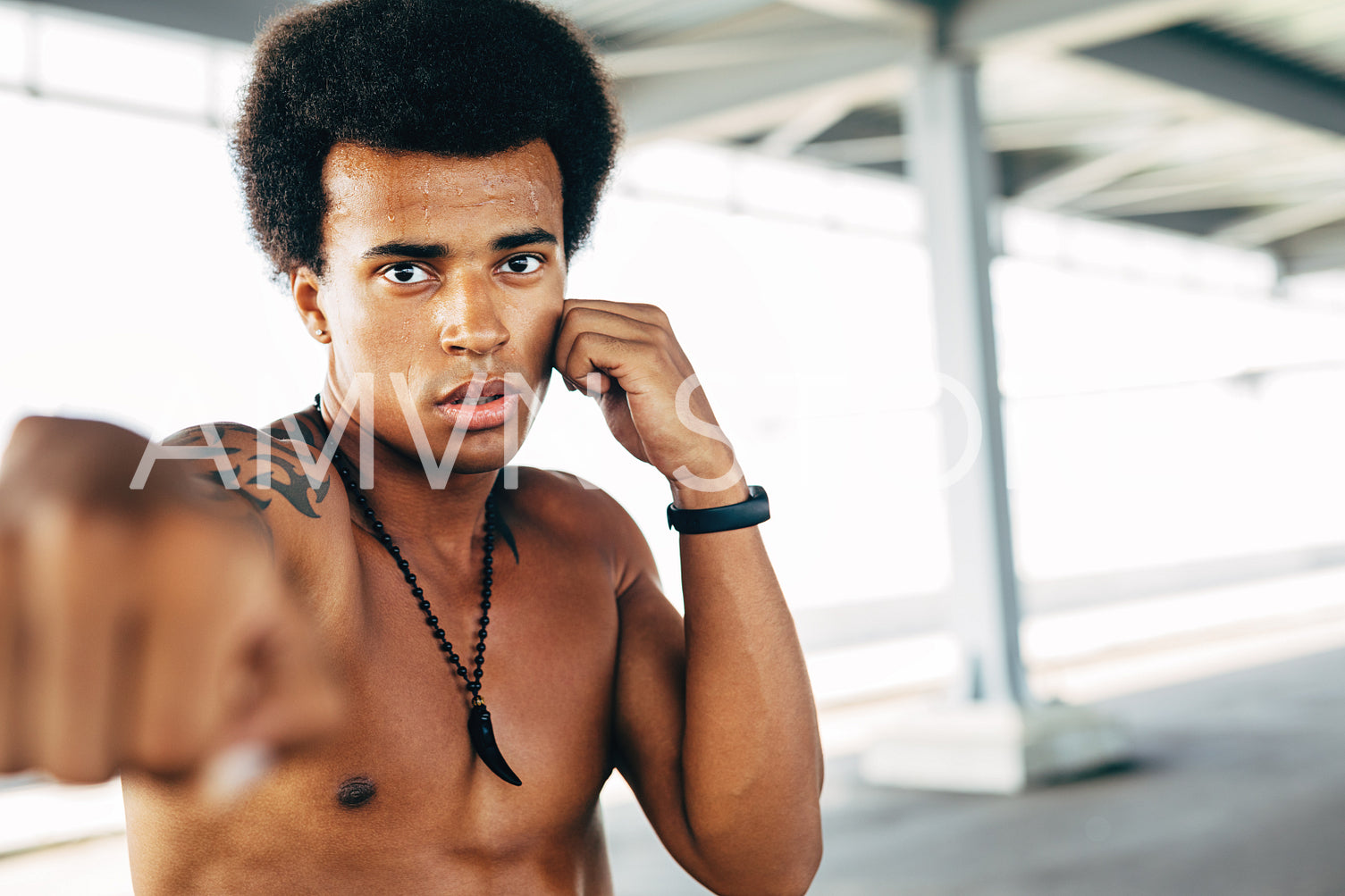 Close up of a male kickboxer doing shadow boxing outdoors	