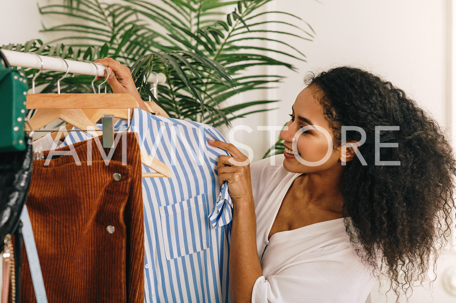 Smiling fashion buyer choose clothes on a rack	