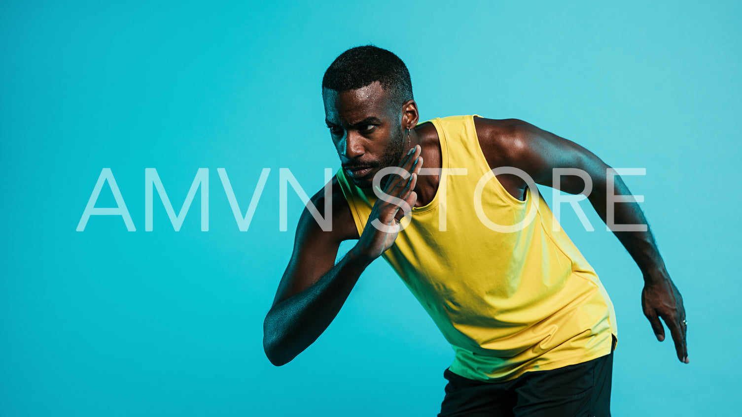 Portrait of a man on blue background in position to start a sprint 