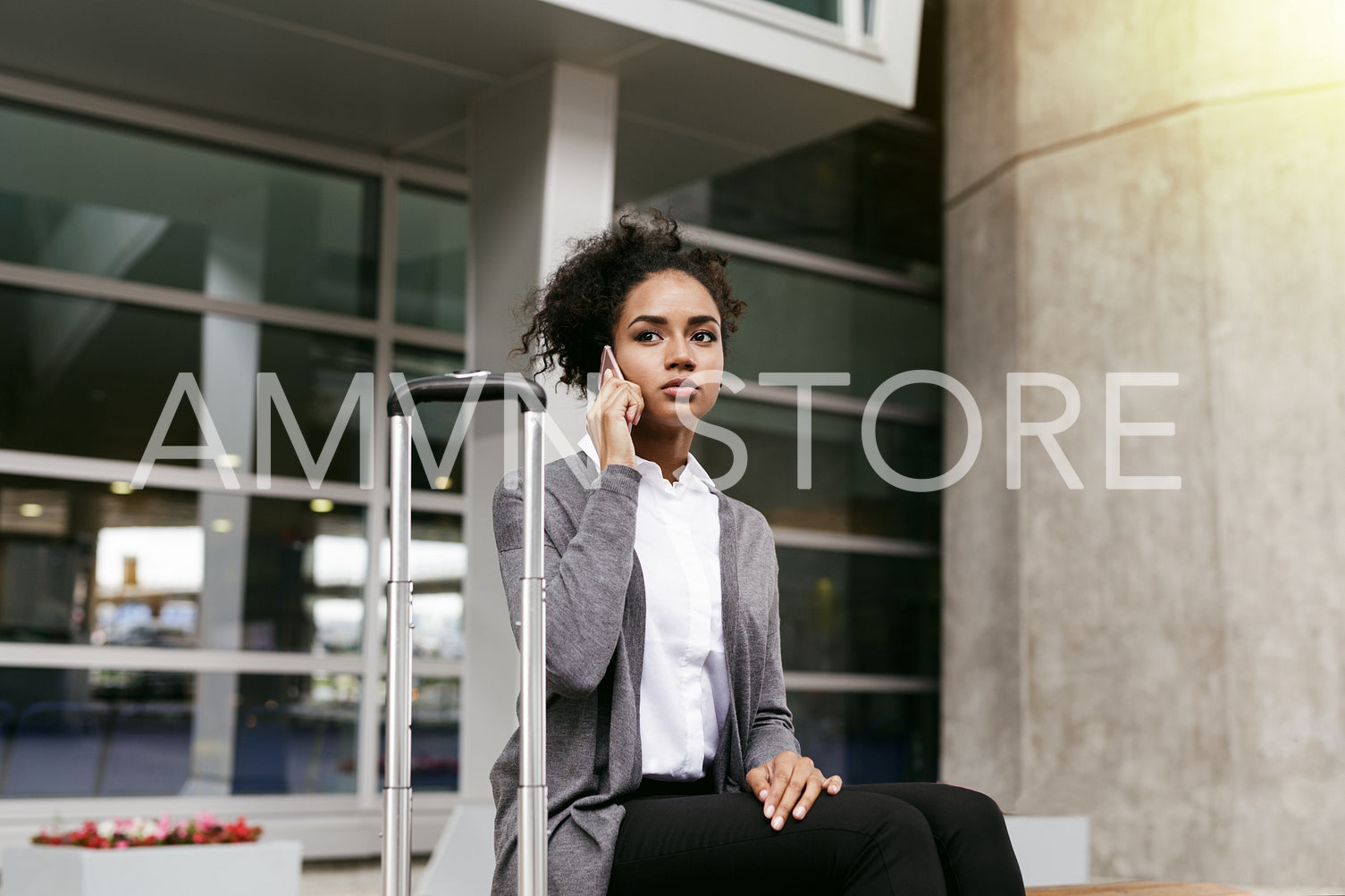 Modern businesswoman sitting at terminal, waiting for taxi	