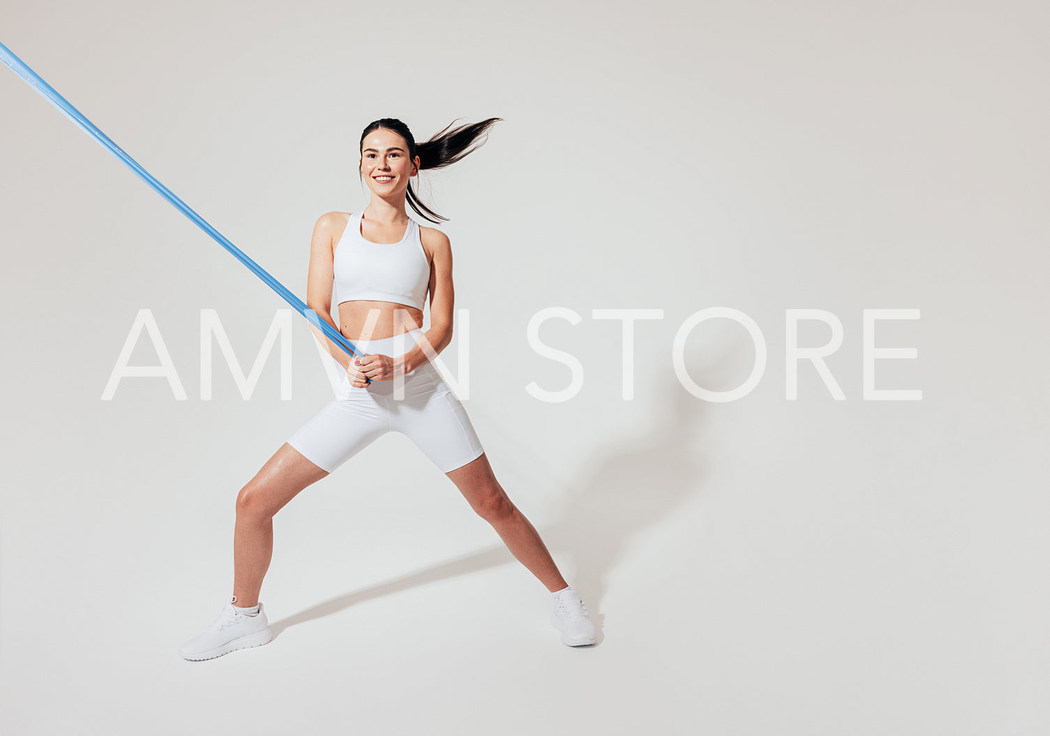 Slim woman with resistance band working out over white background