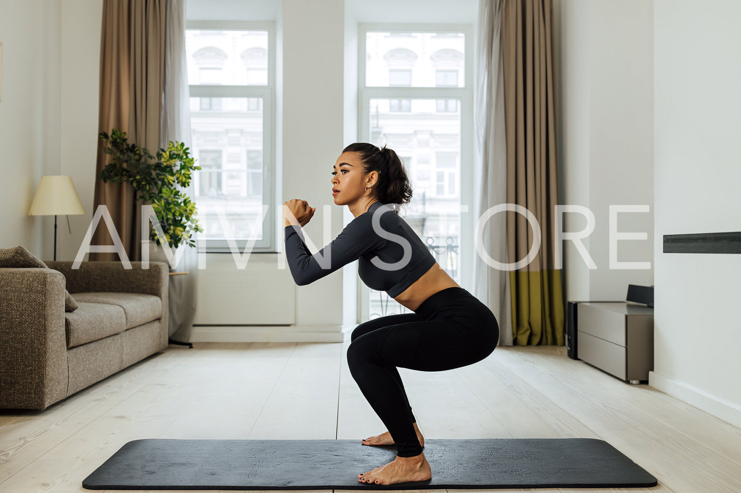 Side view of a fit woman doing sit-ups on mat in living room 