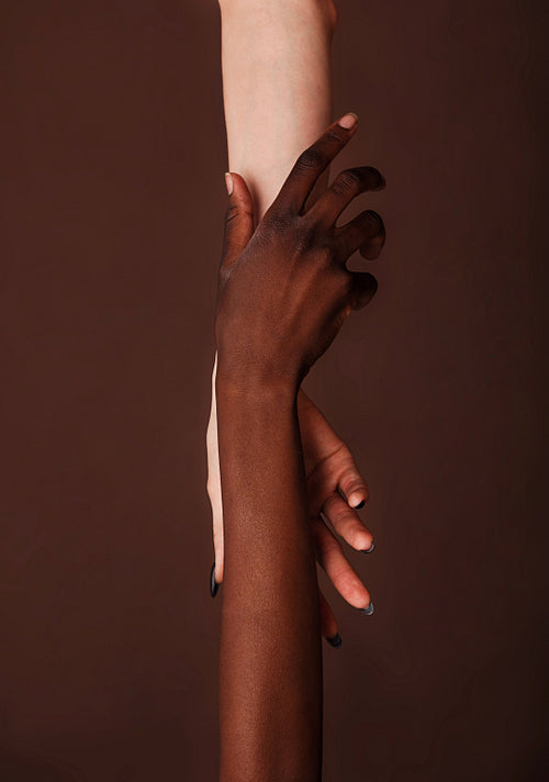 Unrecognizable women's hands against a brown background