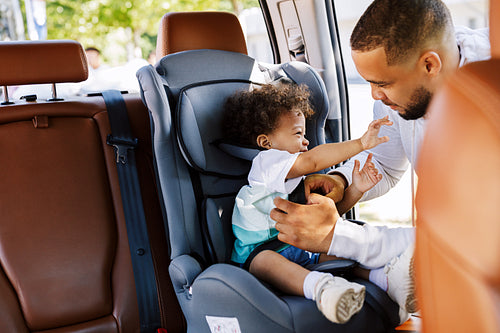 Young father pulls out his son from the baby seat after trip