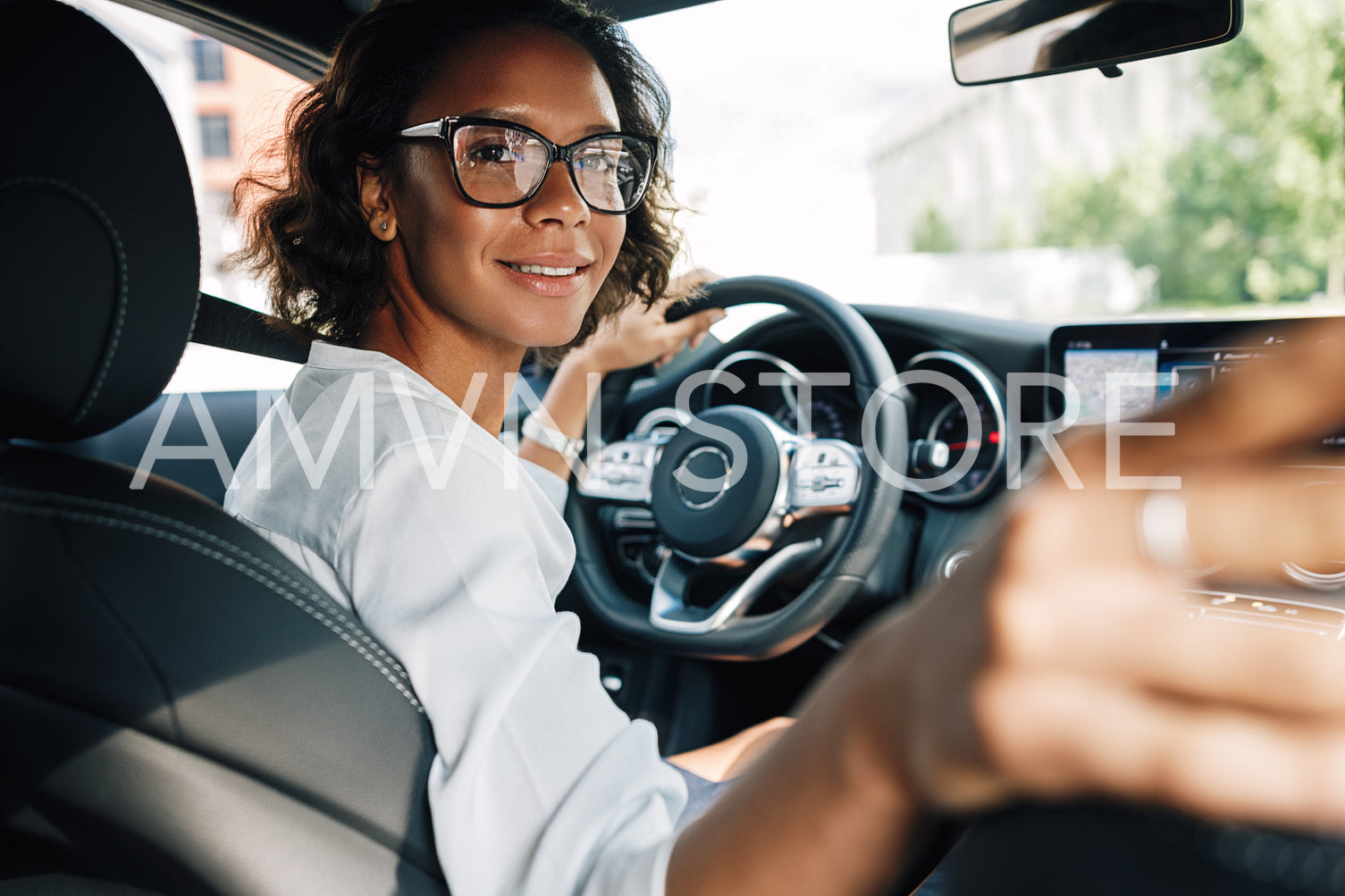 Young smiling woman looking at rear window and parking a car	