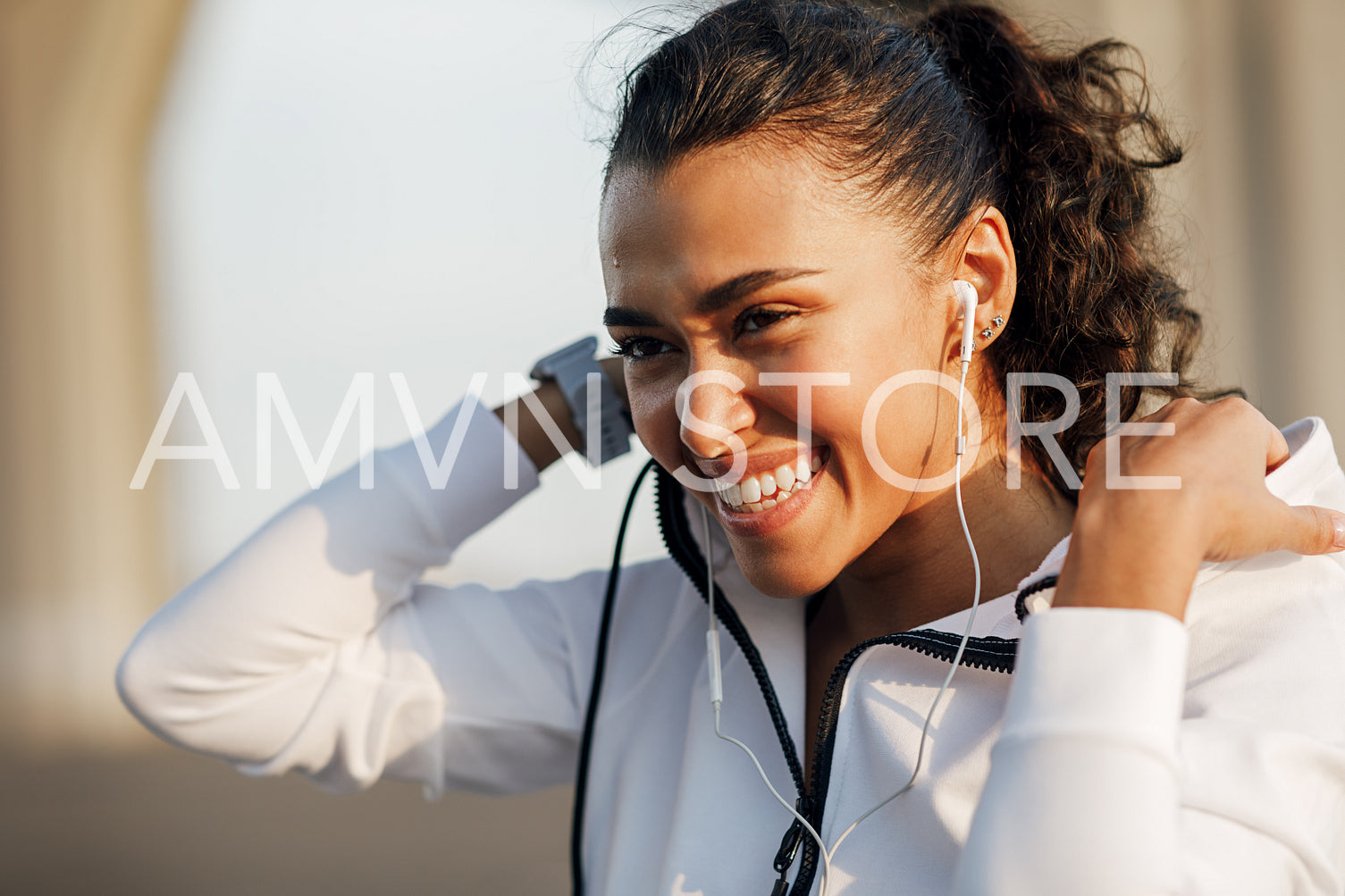 Portrait of a young woman wearing a hoodie and smiling after a workout	