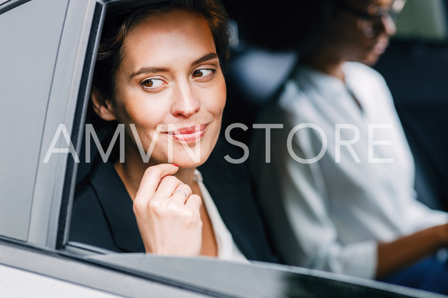 Smiling businesswoman sitting in a cab with her assistant. Two women on a backseat traveling in the car.	