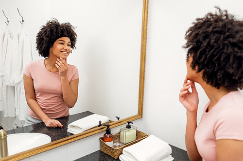 Smiling girl with hair bandage looking at mirror