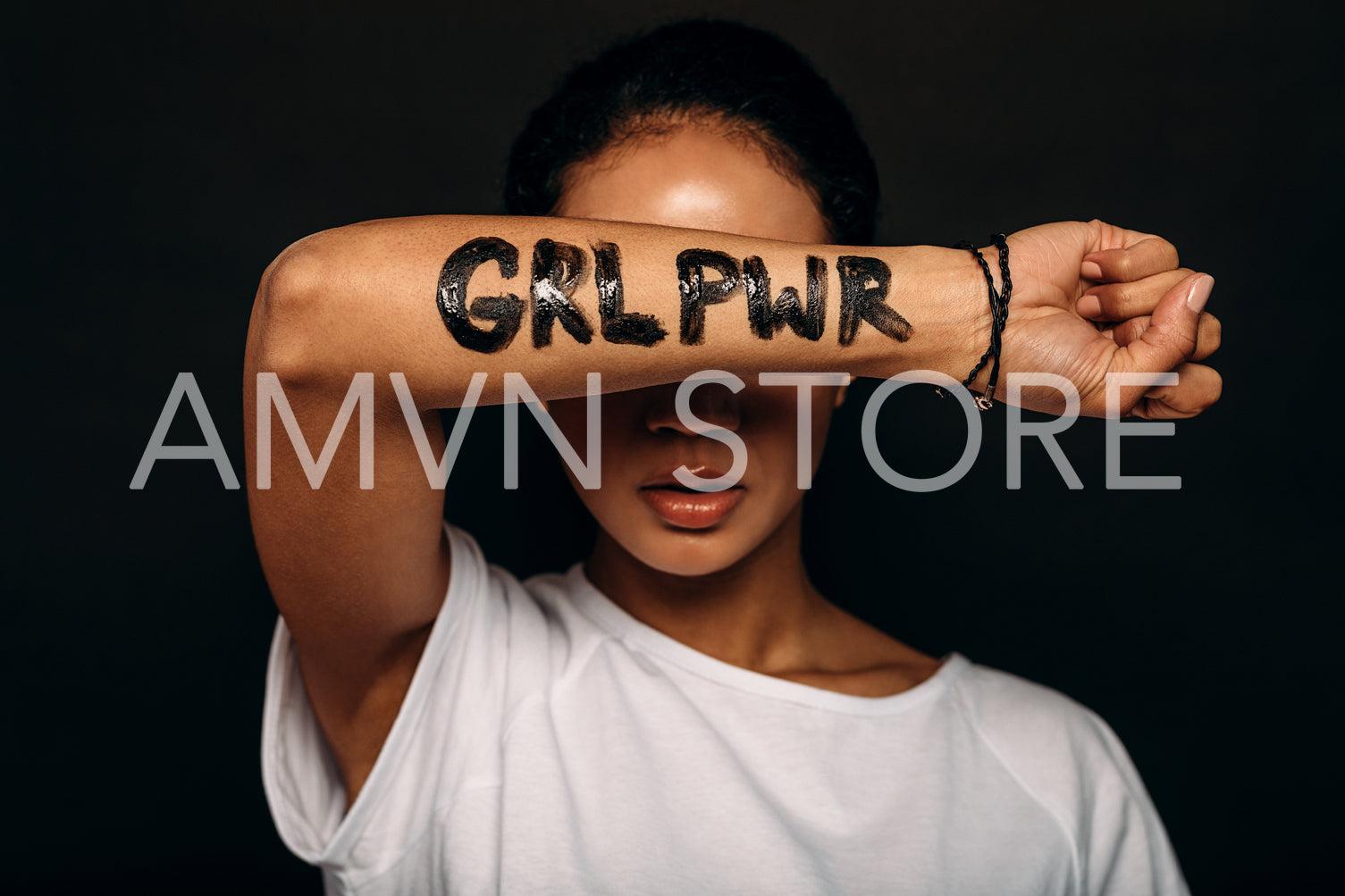 Woman with letters "GRL PWR" written on her hand. Portrait of a woman with arm covering a part of her face.	