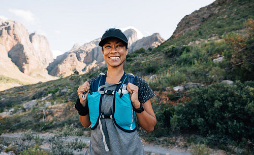 Portrait of a happy trail runner standing in wild terrain