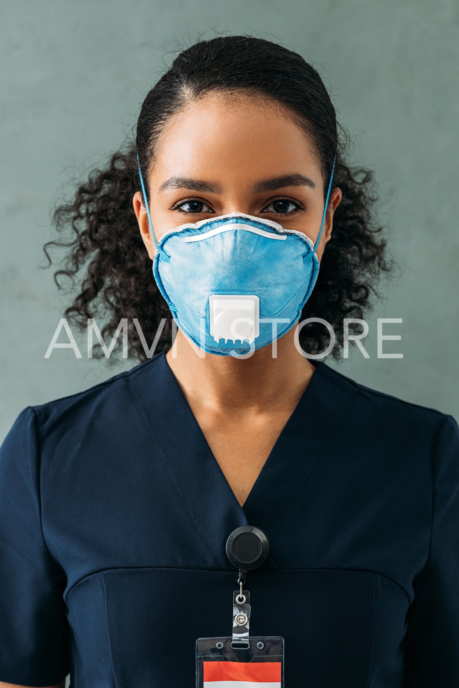 Close up portrait of a female nurse wearing a respirator and looking at the camera