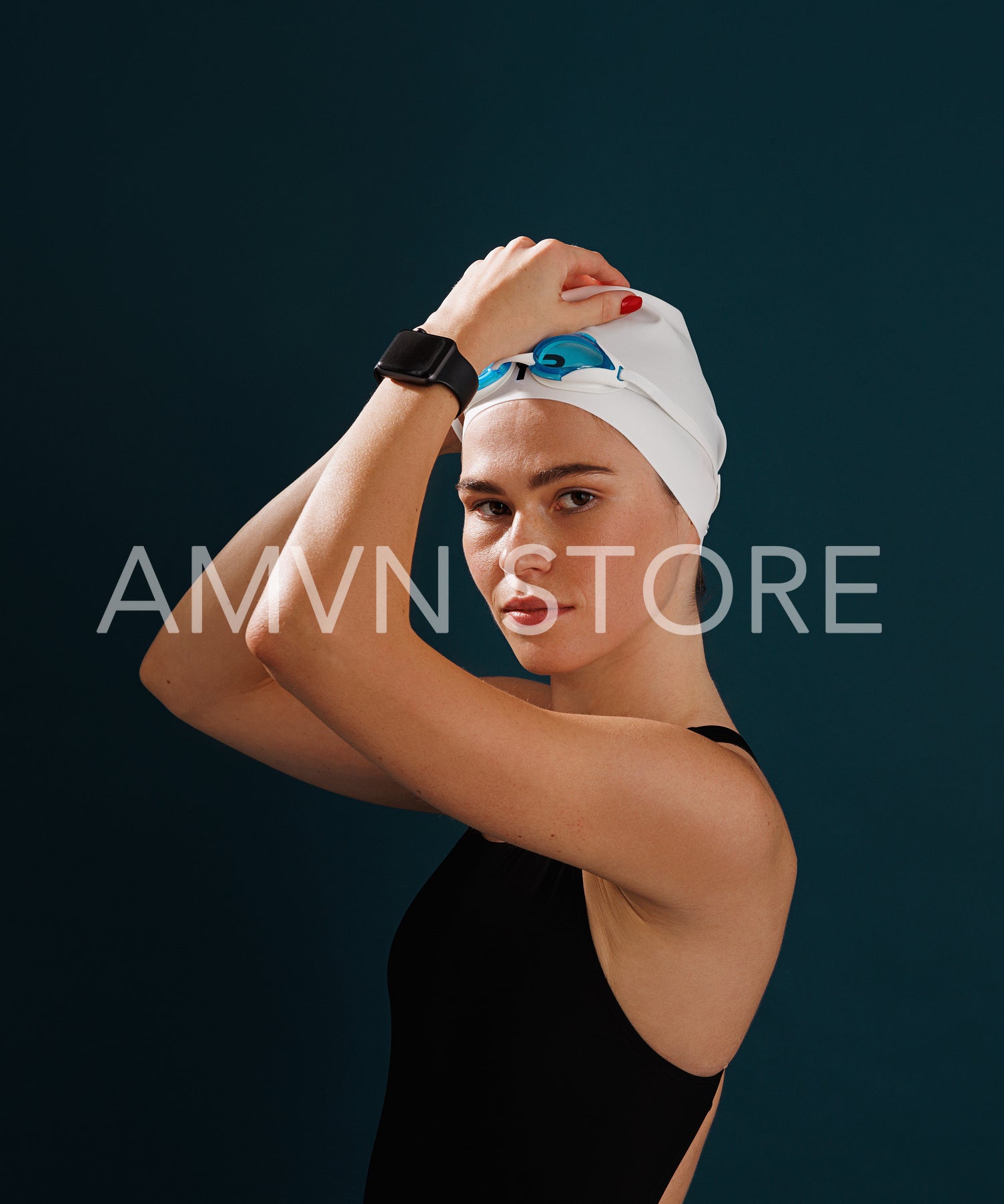 Portrait of a young professional female swimmer looking at the camera against blue background