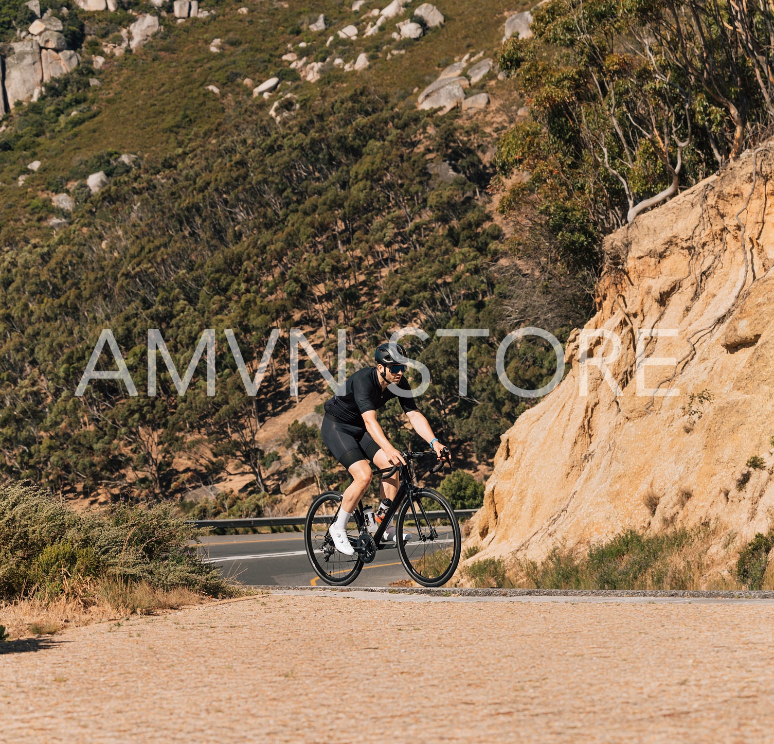 Young male on a bicycle in wild terrain on an empty road