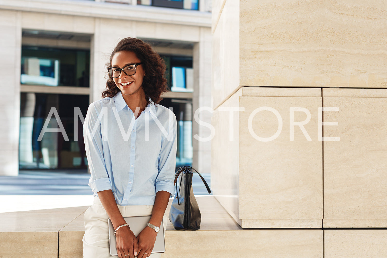 Smiling businesswoman standing outside office building holding a digital tablet	