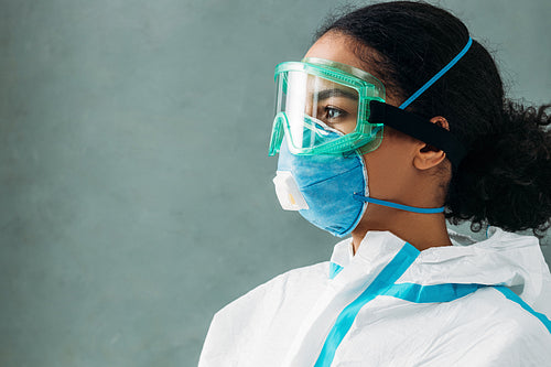 Side view of medical worker wearing suit, respirator and glasses