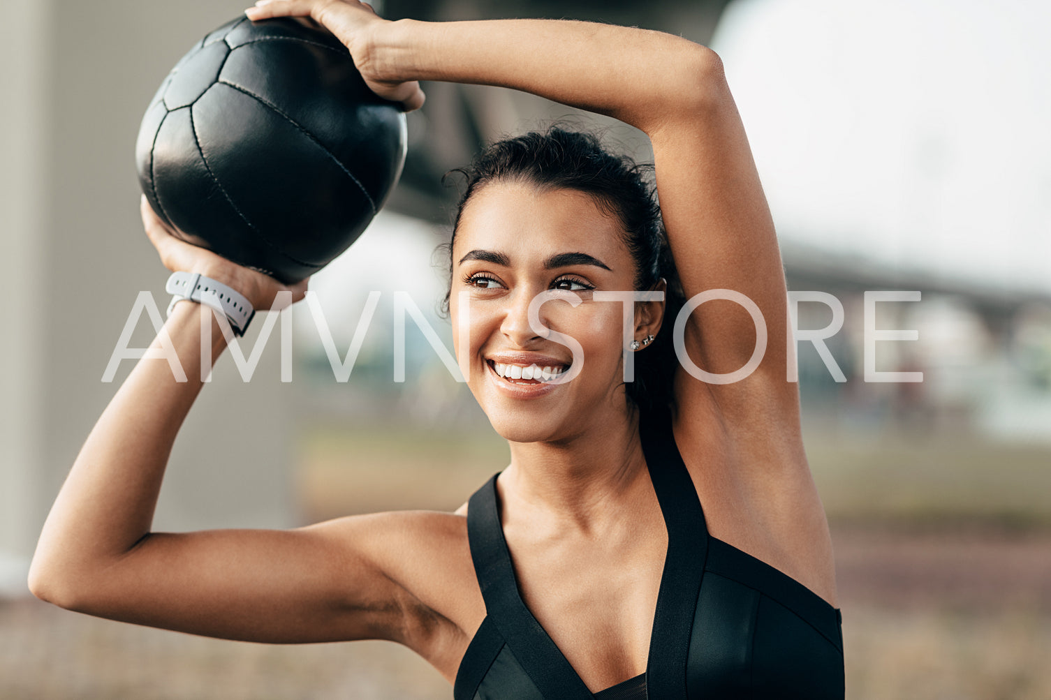 Smiling woman in sport clothes doing fitness training using a medicine ball	