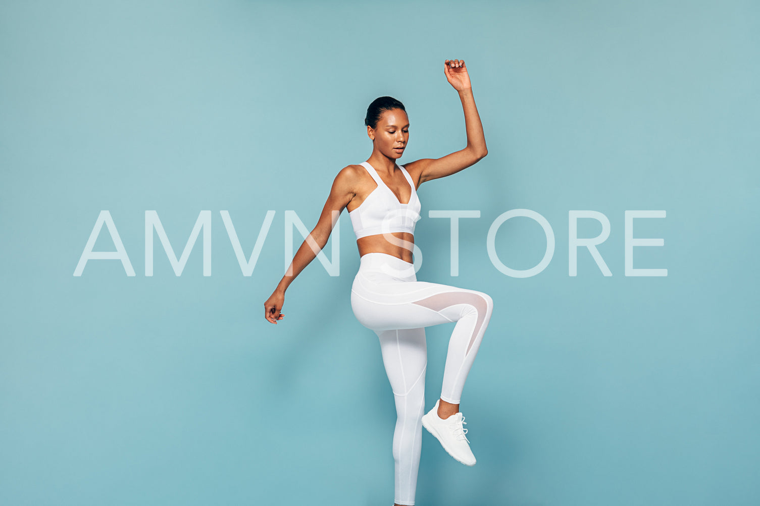 Fitness woman doing cardio training. Young female in sportswear jumping in studio.