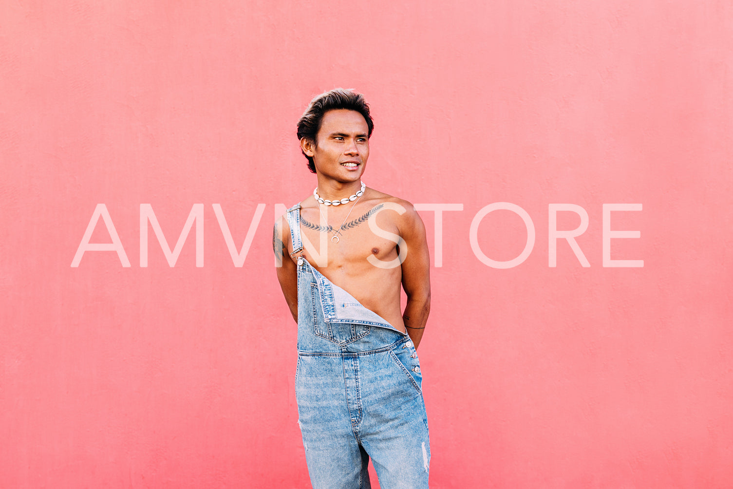 Young handsome man posing outdoors while standing at wall